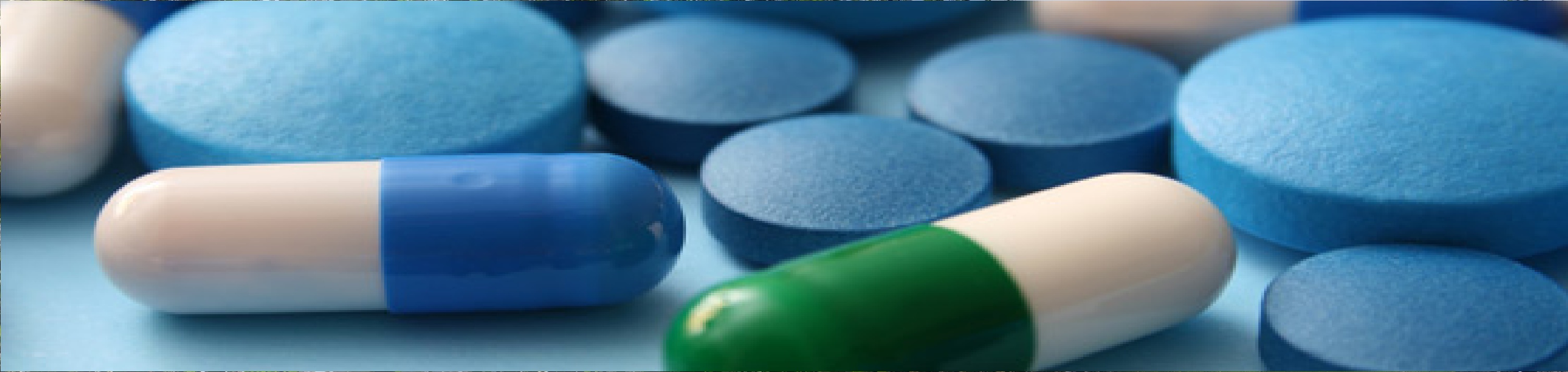 A variety of pharmaceuticals spread out on a piece of blue paper